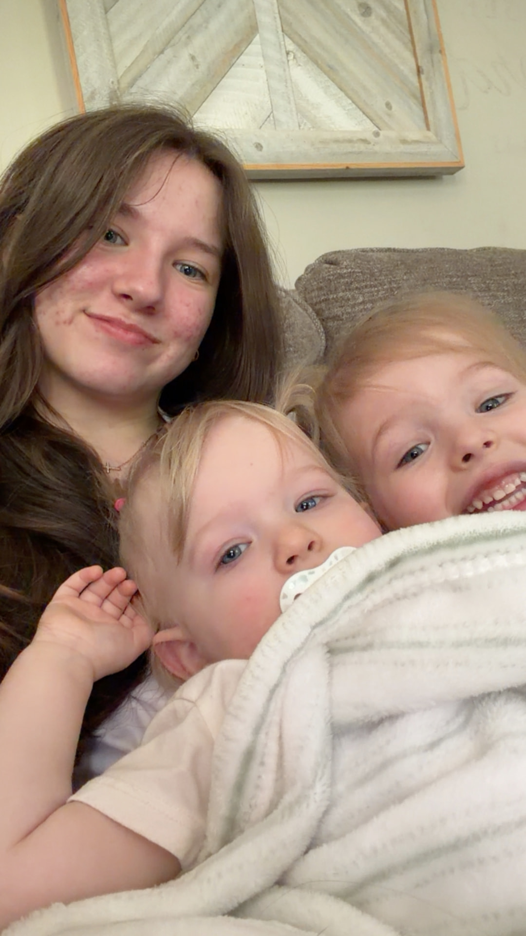 Teen sitter playing with a toddler and a golden retriever puppy in a sunny living room